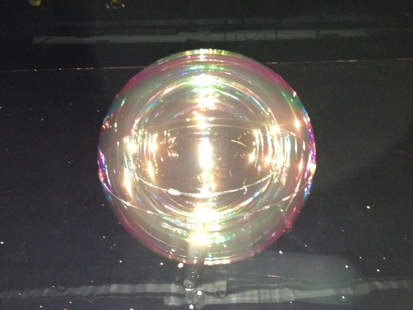 An iridescent bubble lit in the dark