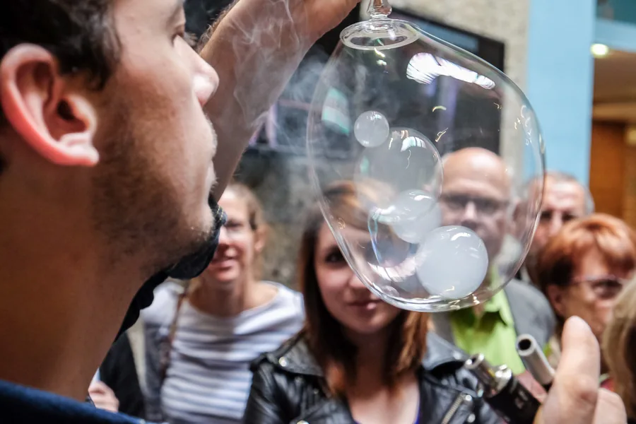 Vincent Wüthrich blows into a bubble containing three others, in front of an audience