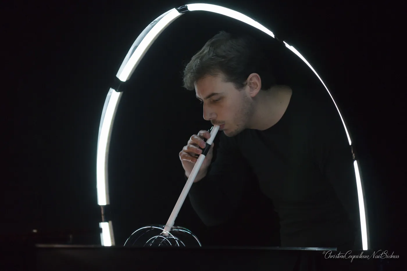 Vincent Wüthrich blows a bubble beneath a lit archway