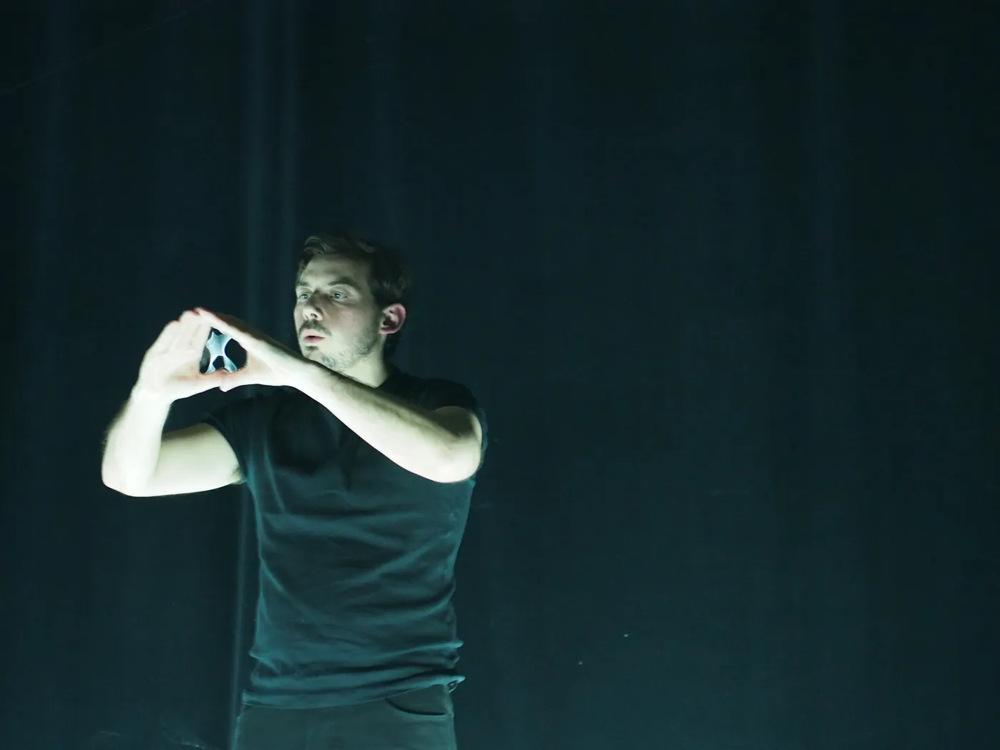 On stage, hands cupped around a bubble